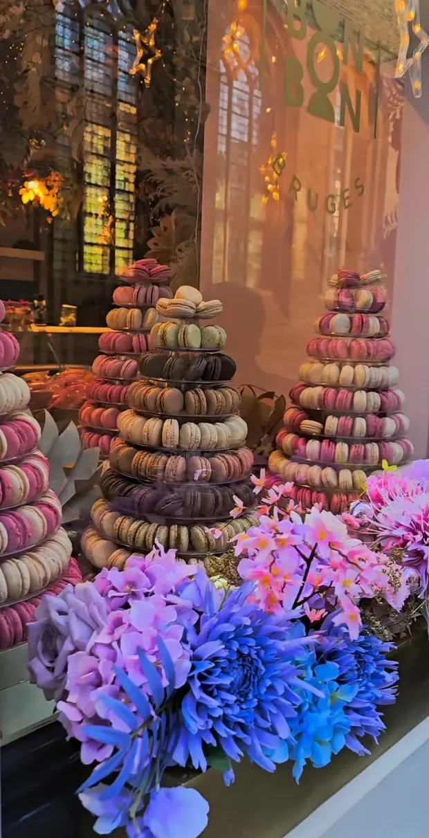 Macaron towers and flowers in a Bruges shop window